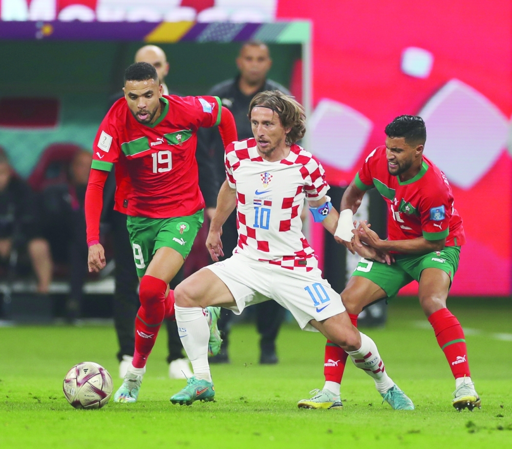 نجم منتخب كرواتيا لوكا مودريتش محاصرا من لاعبا المنتخب المغربي في مباراة تحديد المركز الثالث              تصوير: أحمد البريكي
