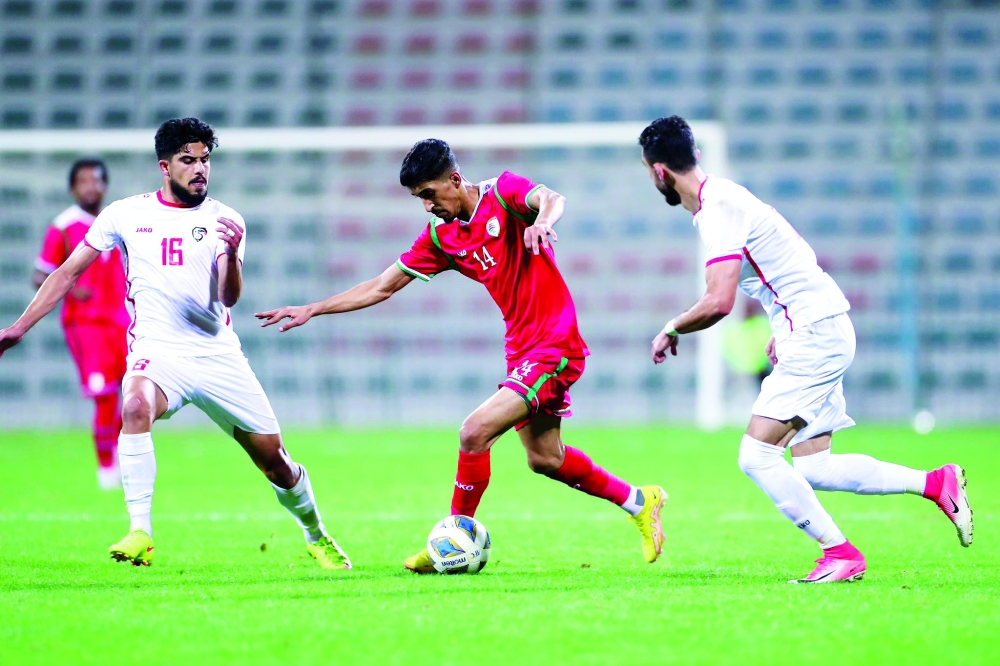 لاعب منتخبنا أحمد الكعبي يستحوذ على الكرة وسط مراقبة من لاعبي المنتخب السوري في اللقاء الودي