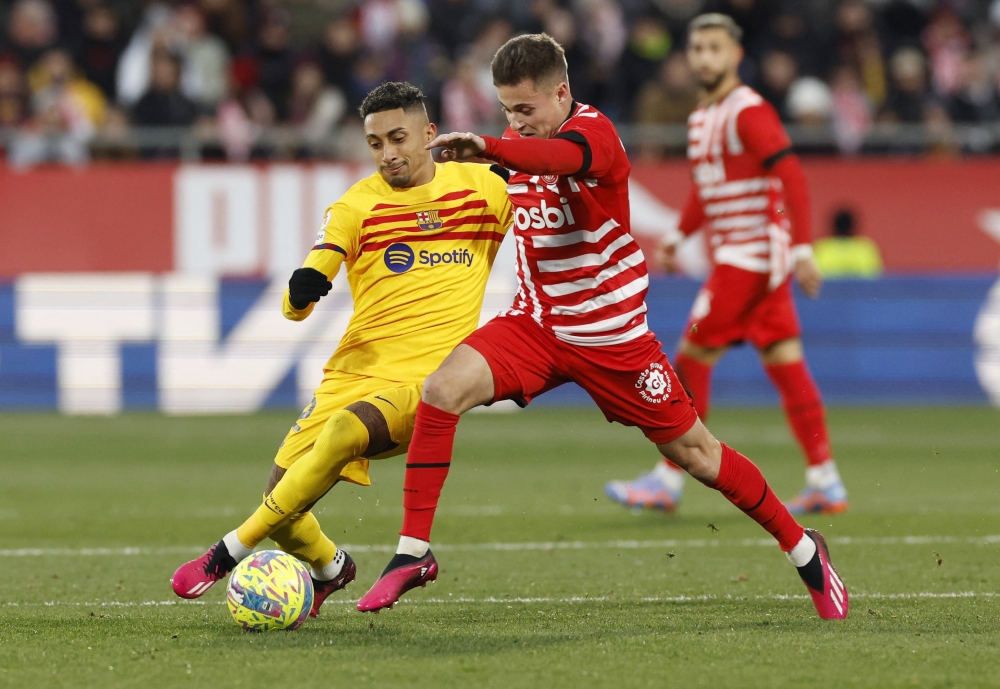 لاعب رافينها لاعب برشلونة يتنافس مع لاعب جيرونا رودريغو ريكيلمي                 المصدر "رويترز"