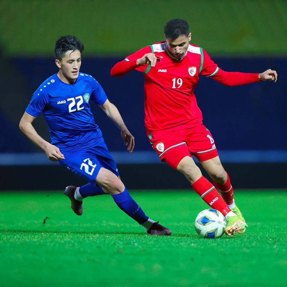 لاعب منتخبنا صلاح الجديدي يستحوذ على الكرة وسط متابعة من لاعب أوزبكستان خلودو راخونوف