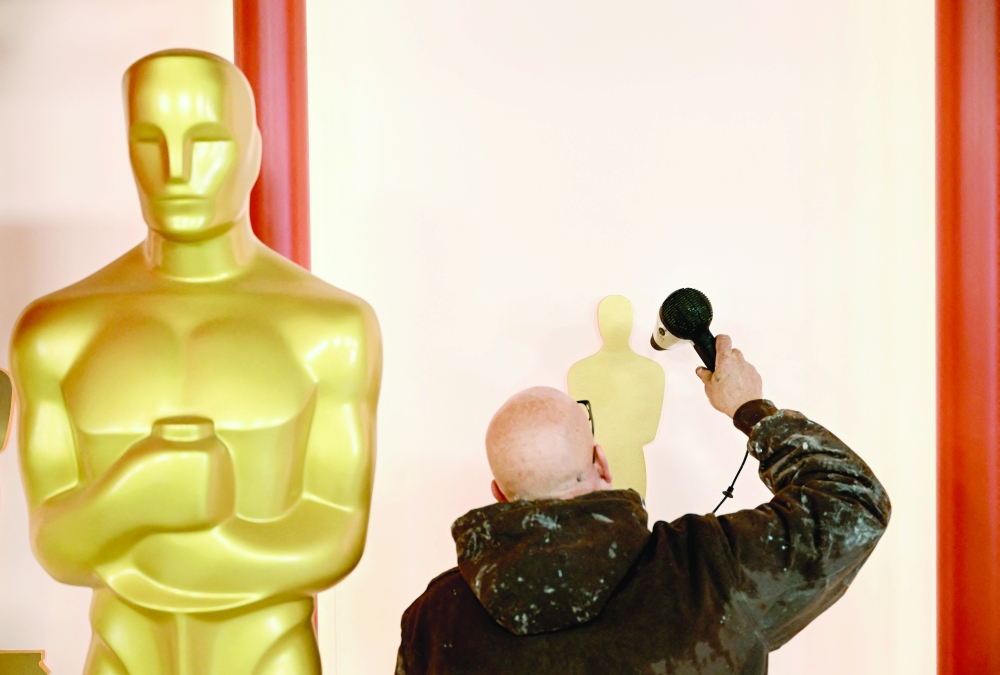 عامل يضع اللمسات النهائية في موقع السجادة الحمراء استعدادا لحفل جوائز الأوسكار.      "أ.ف.ب"