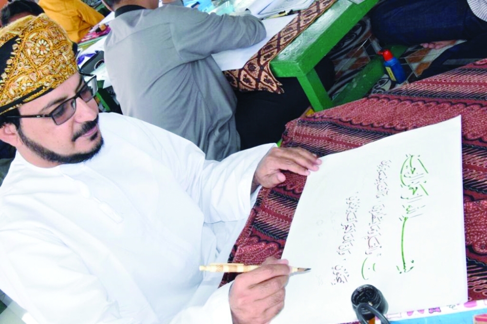 ناصر الذهلي أثناء العمل على لوحة قرآنية 