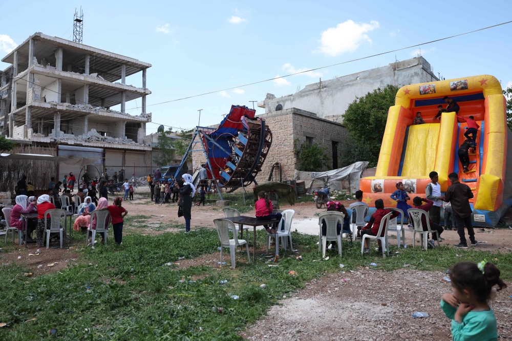 أطفال سوريون يبتهجون بالعيد وسط المباني المتأثرة بالزلزال.          "أ.ف.ب" 