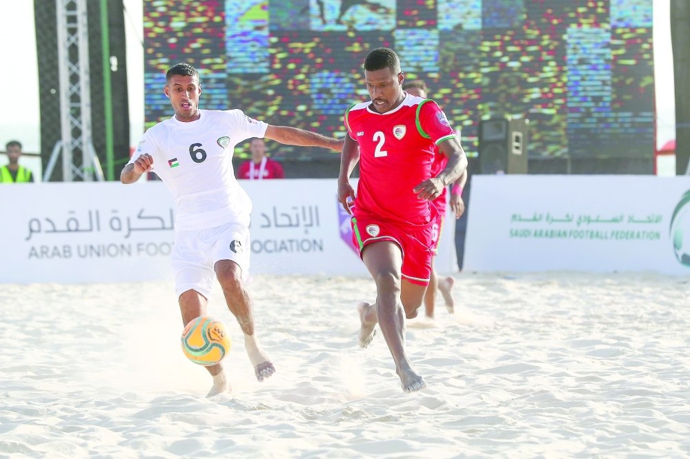 لاعب منتخبنا عبدالله الصوطي يتنافس على الكرة مع لاعب فلسطين