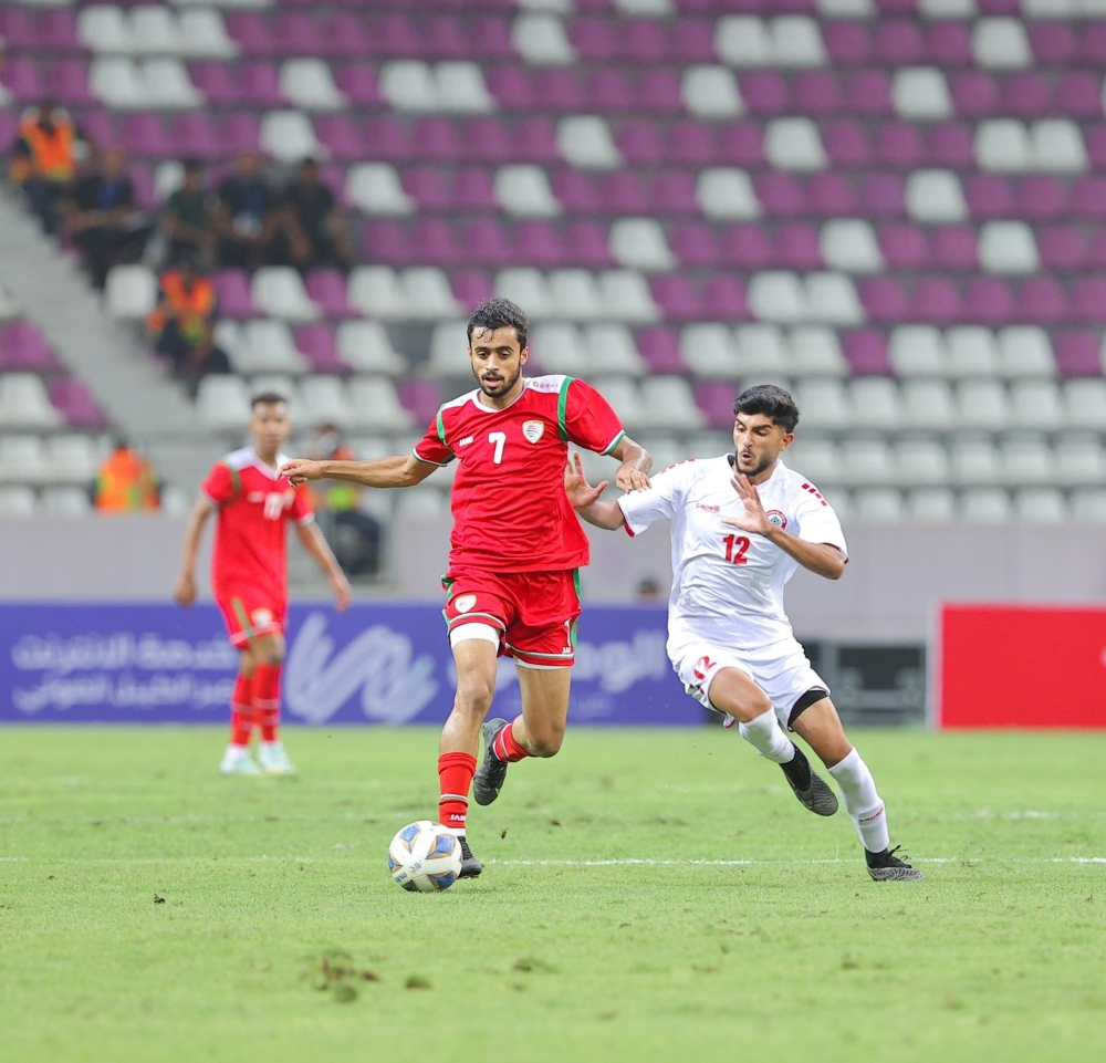 لاعب منتخبنا الأولمبي ناصر الرواحي ينفرد بالكرة وسط متابعة من محمود زبيب لاعب منتخب لبنان 