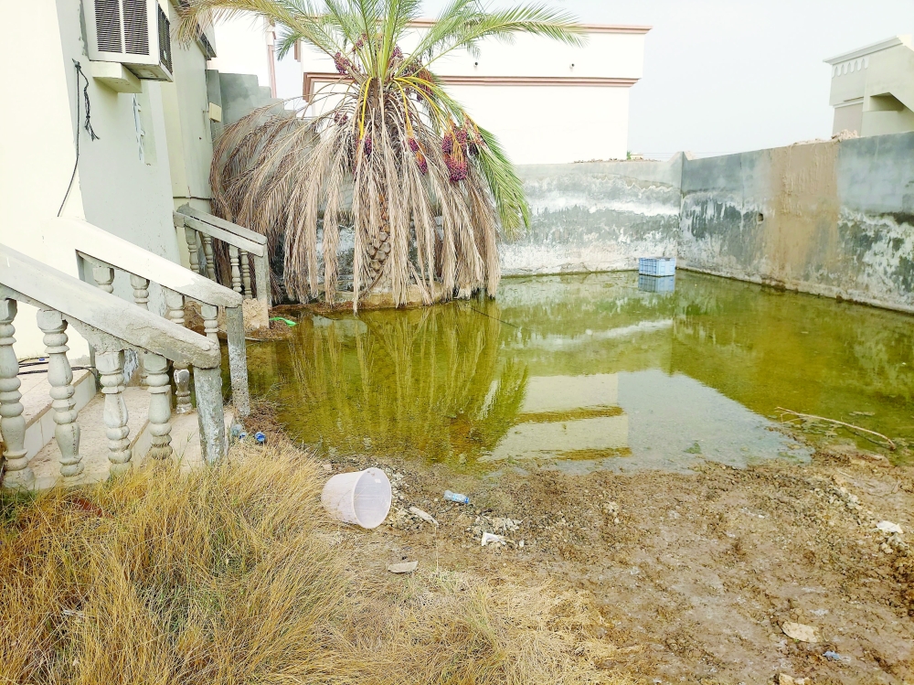 مدخل أحد المنازل محاط بالمياه المتدفقة من شبكة المياه الحكومية في جعلان بني بوعلي