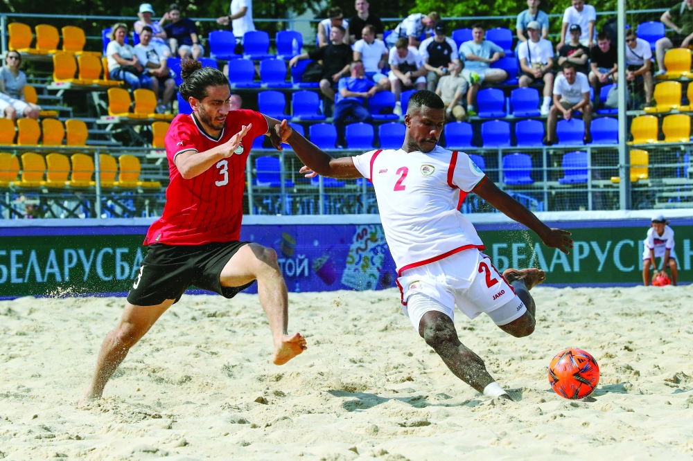 لاعب منتخبنا عبدالله الصوطي يسدد الكرة وسط متابعة من لاعب المنتخب المصري