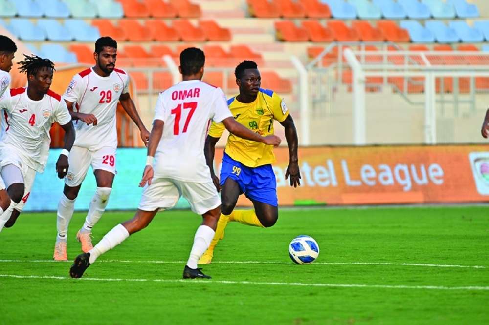 محترف بهلا ينطلق بالكرة وسط متابعة من لاعبي نادي عمان                   "تصوير: فيصل البلوشي"