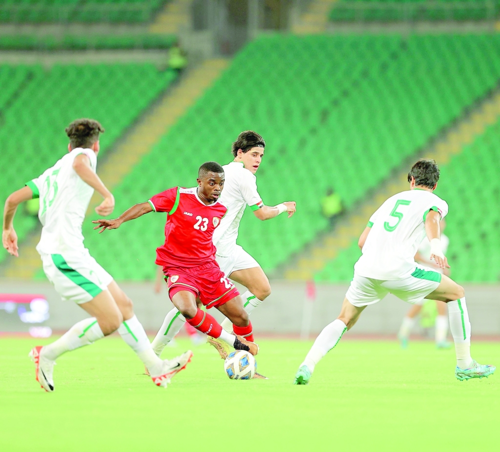 لاعب منتخبنا ملهم السنيدي يستحوذ على الكرة وسط مراقبة من لاعبي العراق