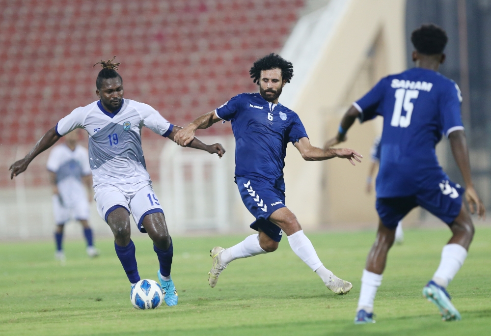 محترف نزوى يحاول المرور من لاعبا صحم في اللقاء   ...     تصوير: أحمد البريكي