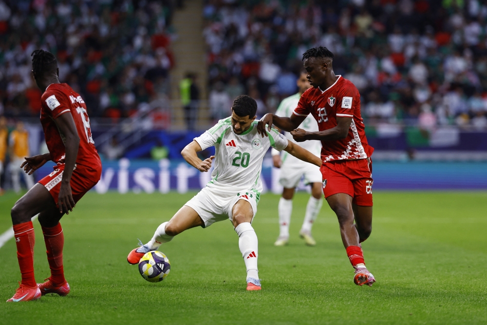 لاعب الجزائر يوسف عطال يتنافس على الكرة مع لاعب السودان القزولي نوح