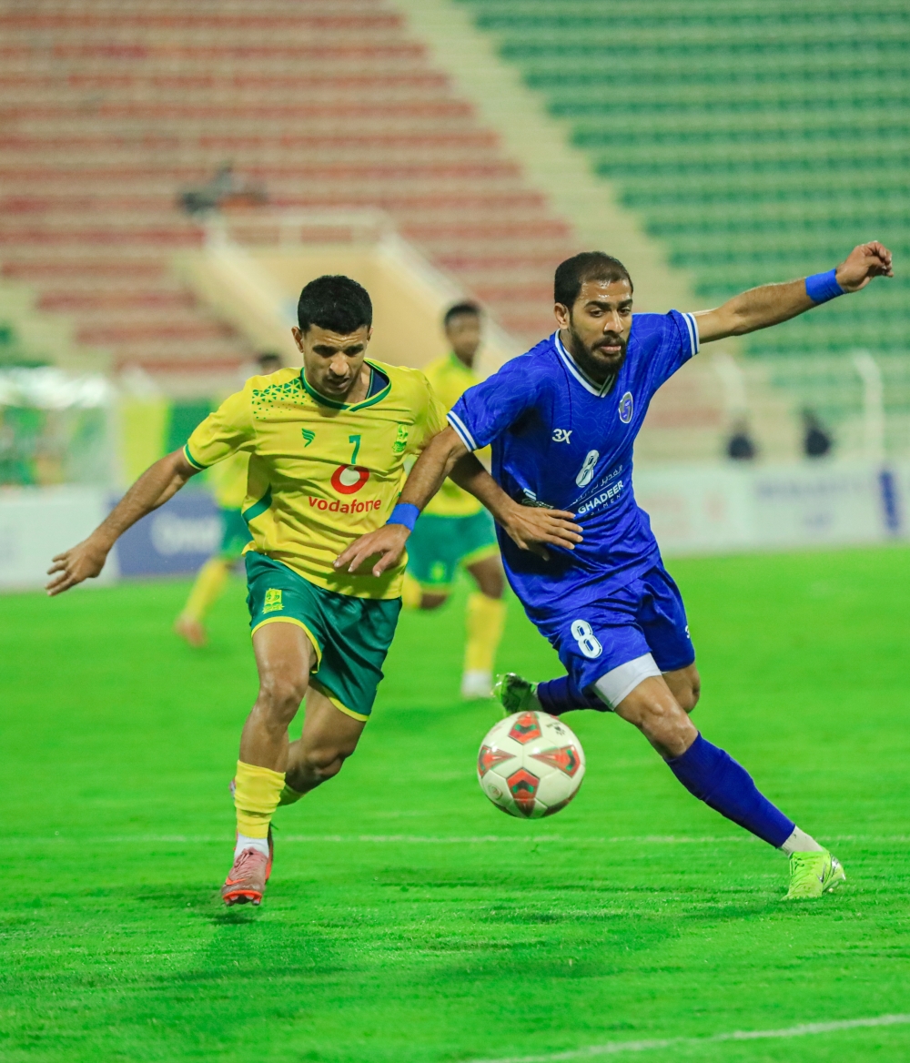 لاعب صحم محمد البلوشي يتنافس على الكرة مع لاعب السيب زاهر الأغبري